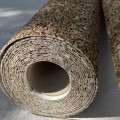 Rolka tapety z naturalnej miki z widoczną strukturą drobnych płatków mineralnych. Zbliżenie pokazuje naturalny połysk, nieregularną powierzchnię oraz warstwową budowę dekoracyjnej okładziny ściennej.